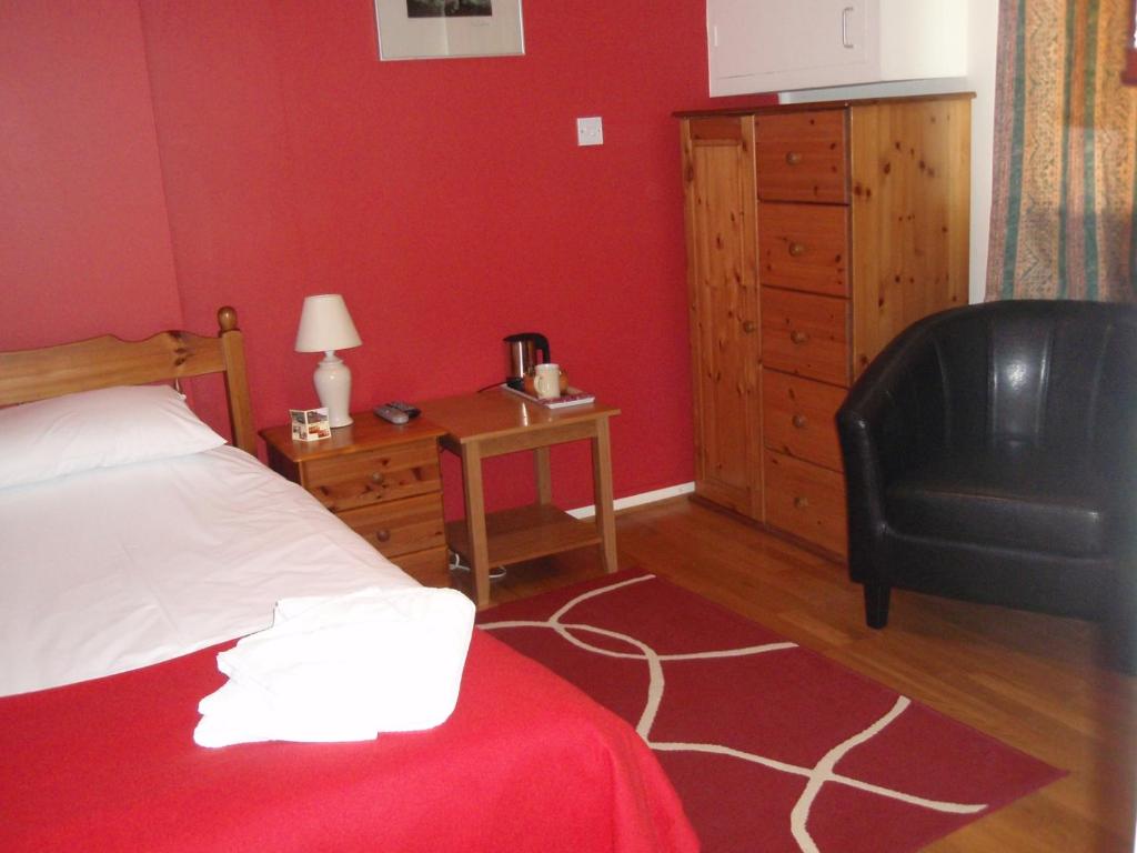 a bedroom with a bed and a chair and a desk at Red Lion Accommodation in Abingdon