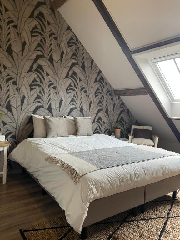 a bedroom with a large bed with a wall at De Zuileshoeve in Dordrecht