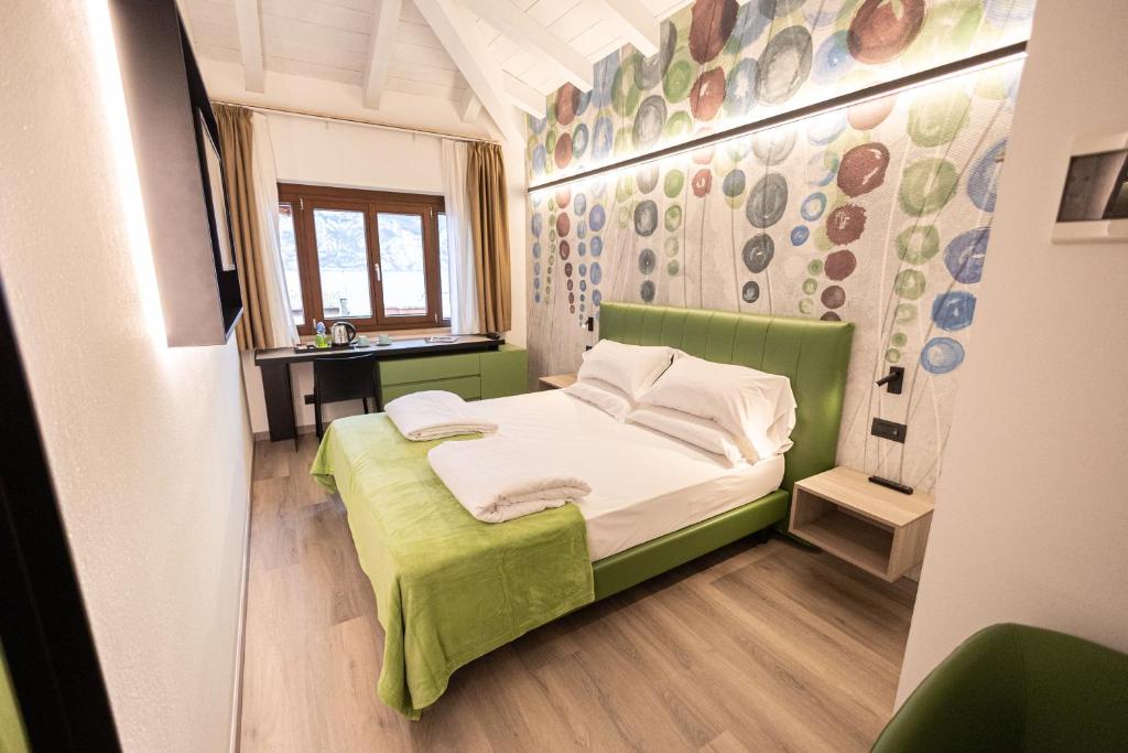 a small bedroom with a green bed and a window at Hotel Lago Di Garda in Malcesine