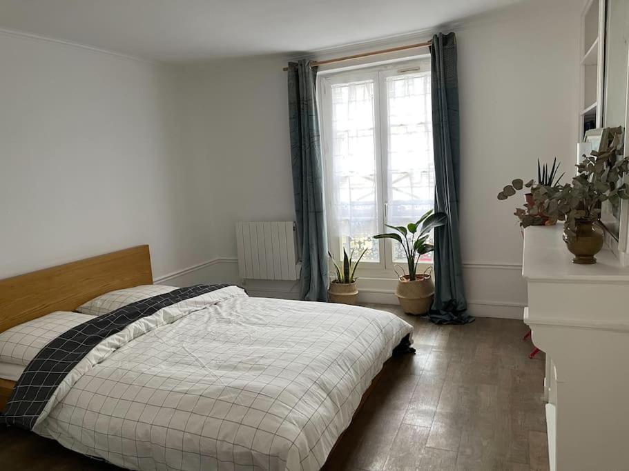 een slaapkamer met een bed en een raam en planten bij Vavin luxembourg garden in Parijs