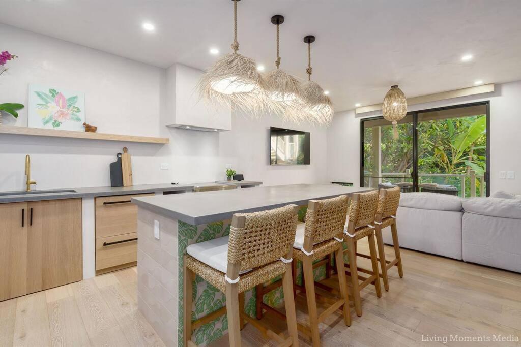 a kitchen with a table and chairs and a couch at Aloha Moon - A Chic and Dreamy Modern Tropical Hideaway! in Wailea