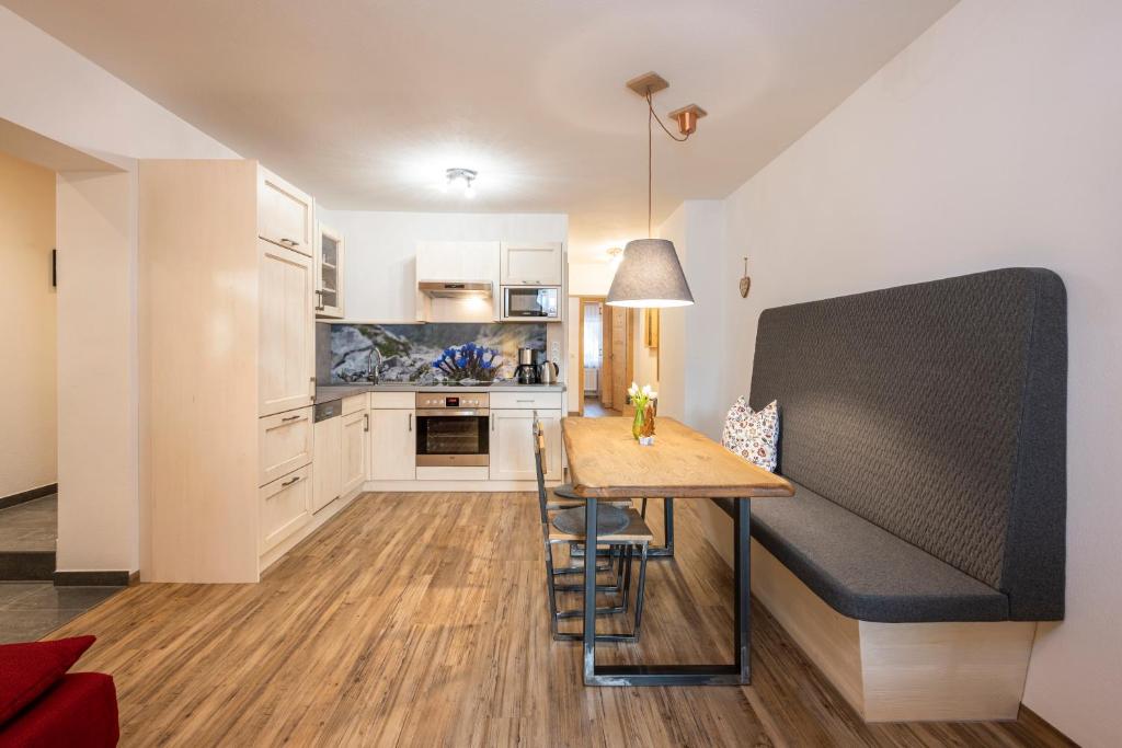 een keuken en eetkamer met een tafel en een bank bij Tauerncamping Apartment in Radstadt