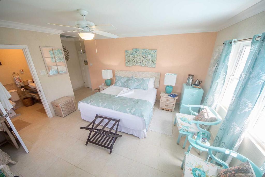 a bedroom with a bed and a chair in it at Hidden Gem Barbados in Christ Church