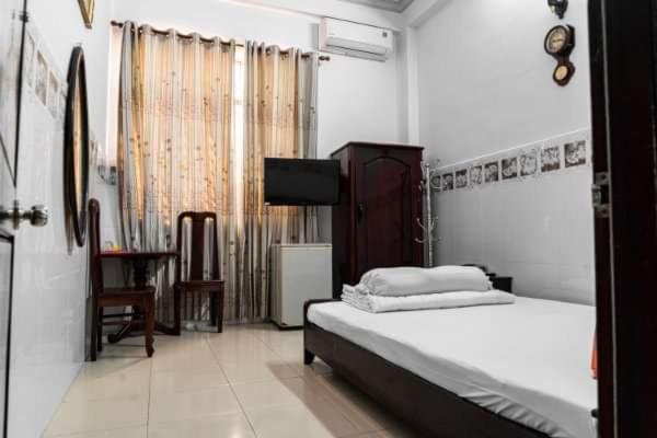 ein Schlafzimmer mit einem Bett und einem TV. in der Unterkunft Khách Sạn Tú Anh in Hà Tiên
