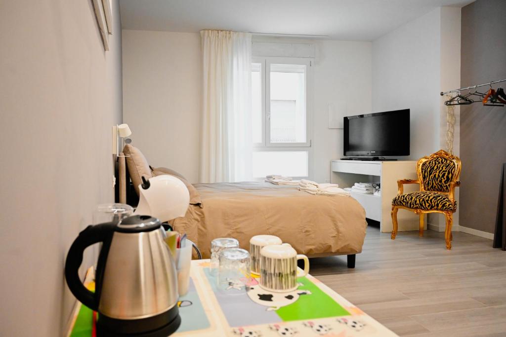 een slaapkamer met een bed en een tafel met een waterkoker bij Cozy Studio Downtown in Bassano del Grappa