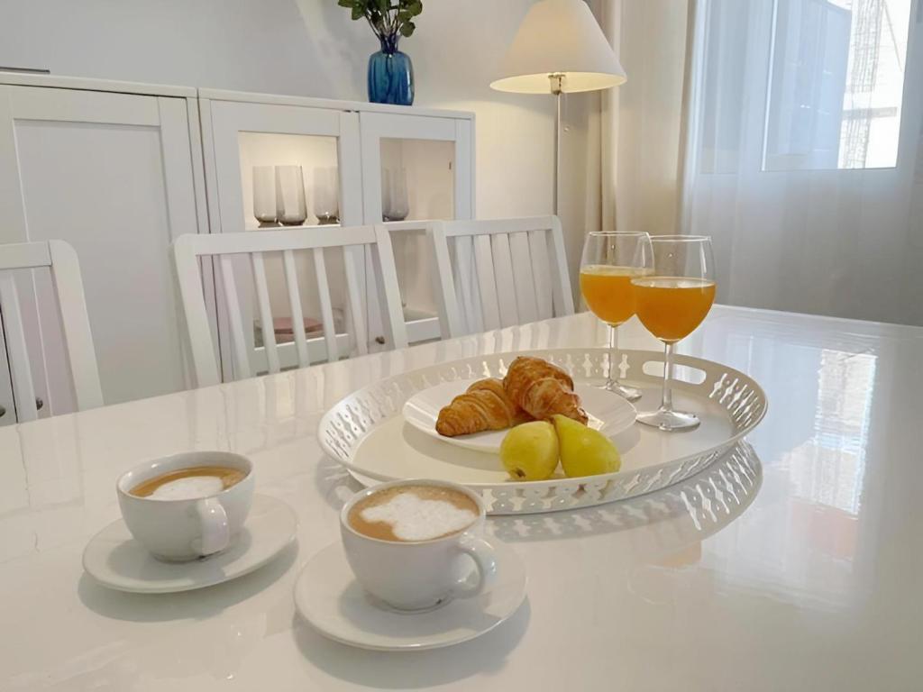 a table with two cups of coffee and two glasses of orange juice at C. del Mar - de Luxe apartament Centrum Torrevieja in Torrevieja