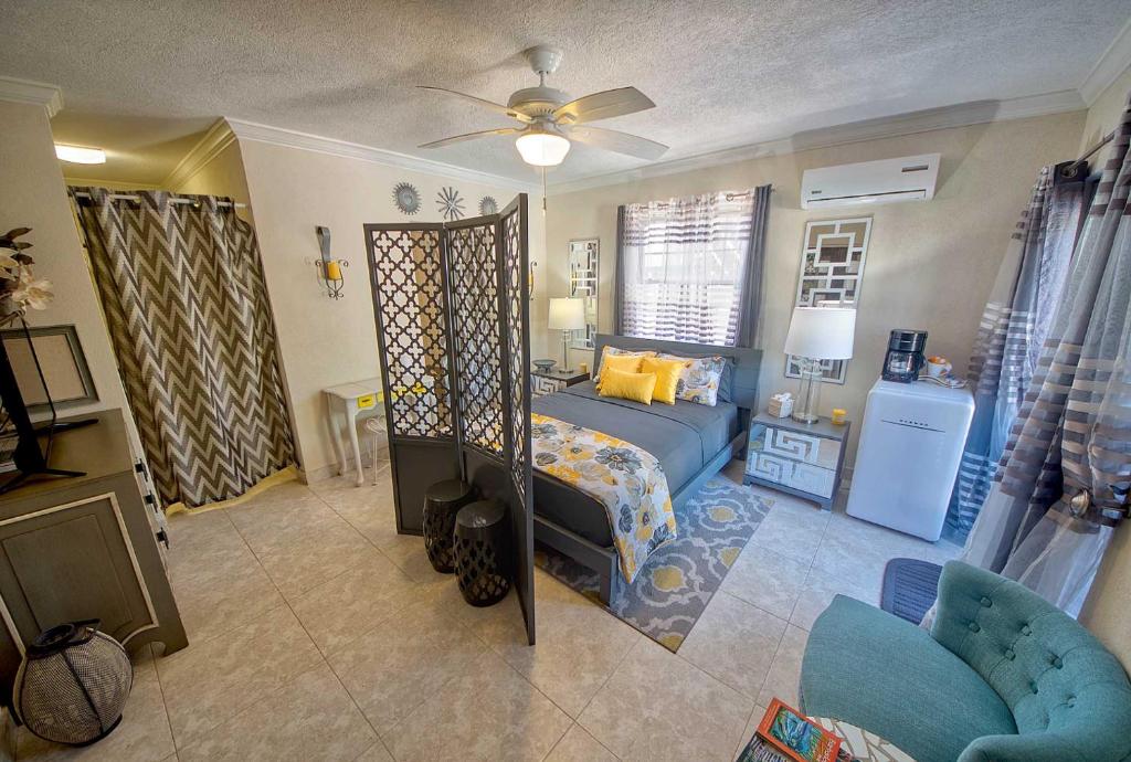 a bedroom with a bed and a ceiling fan at Hidden Gem Barbados in Christ Church