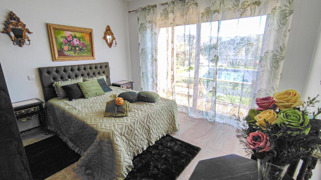 a bedroom with a bed and a large window at Quinta dos Padrinhos - Suites in the Heart of the Douro in Lamego