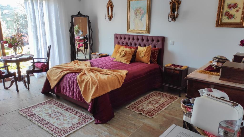 a bedroom with a bed with a purple bedspread at Quinta dos Padrinhos - Suites in the Heart of the Douro in Lamego
