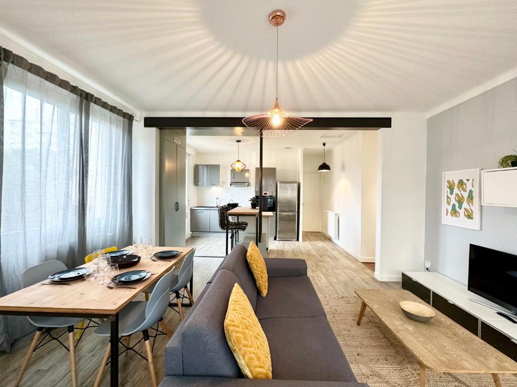 ein Wohnzimmer mit einem Sofa und einem Tisch in der Unterkunft DESIGN MODERNE SPACIEUX - Familial in Mont-de-Marsan
