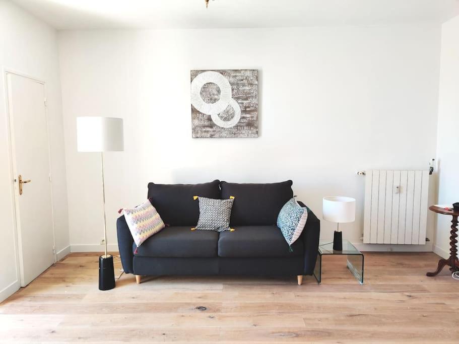 un salon avec un canapé noir dans une pièce dans l'établissement Top floor nest, balcony close to sea and old-town, à Nice