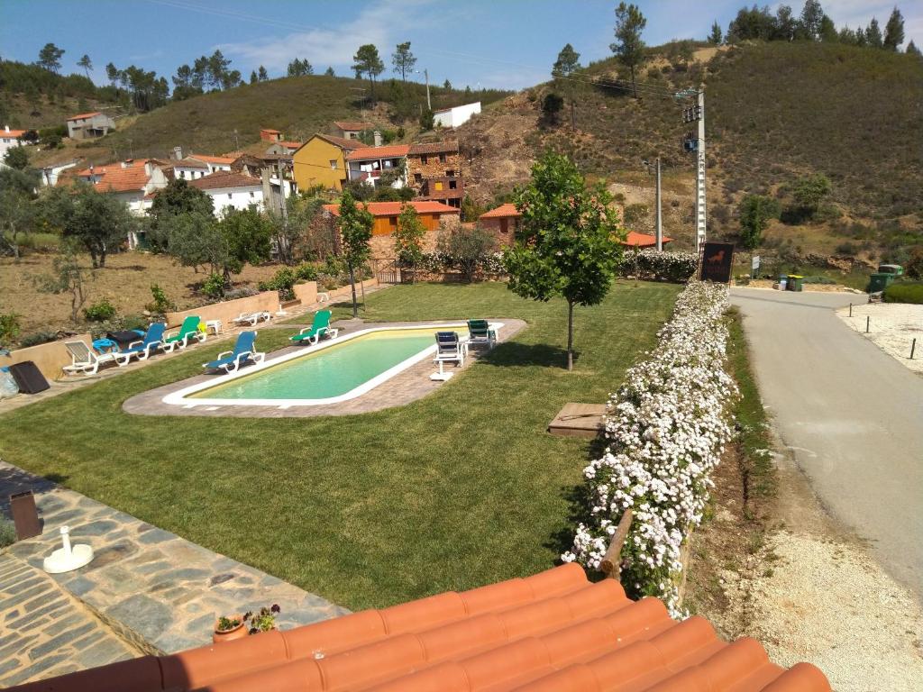 a view of a yard with a swimming pool at REFÚGIO DO RAPOSO/CASA VEGA in Montes da Senhora