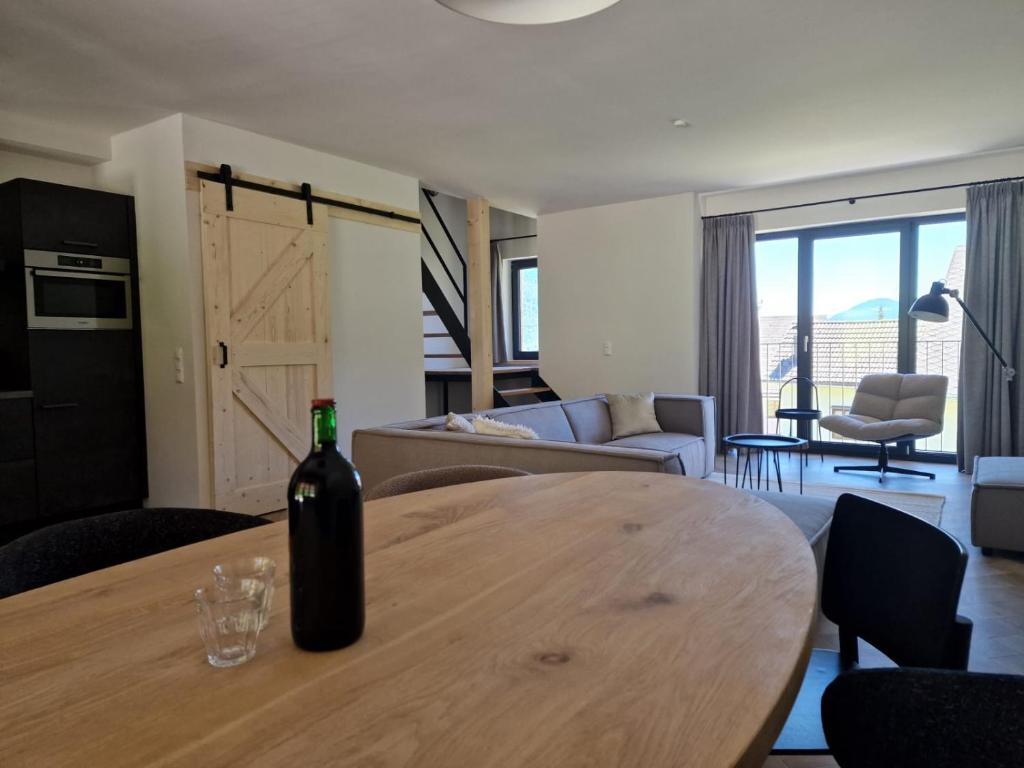 eine Flasche Wein auf einem Holztisch im Wohnzimmer in der Unterkunft Weißbriach Lodge in Weissbriach