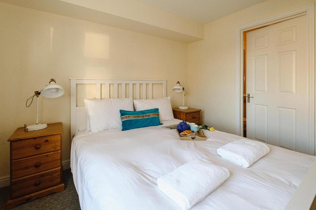 a bedroom with a large white bed with two pillows at 1 Coastguard Court in Aldeburgh