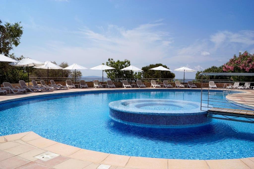 duży basen z krzesłami i parasolami w obiekcie F2 vue mer dans résidence avec piscine w Ajaccio