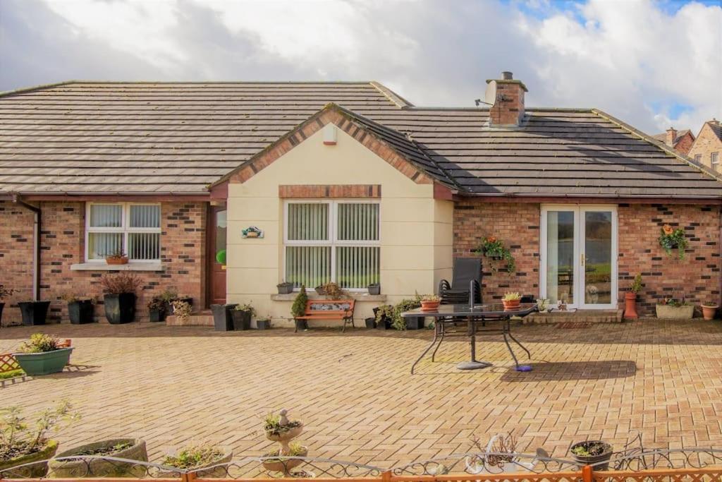 a brick house with a table in front of it at THE LAKE HOUSE: a delightful and peaceful retreat. in Derrymacash