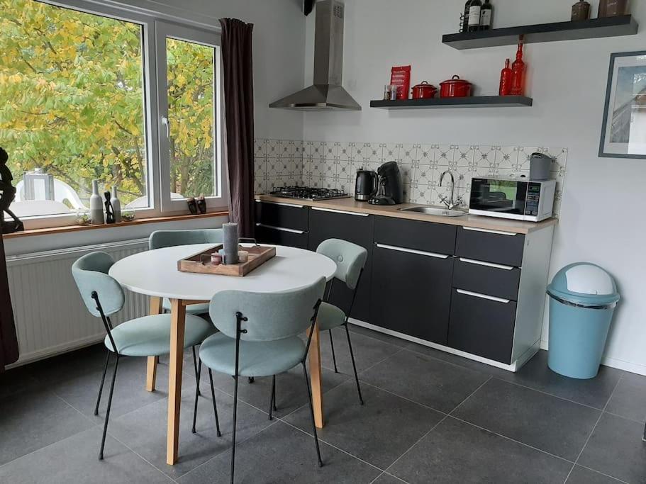 een keuken met een tafel en stoelen bij Vrijstaande recreatievilla met ruime omheinde tuin in Posterholt