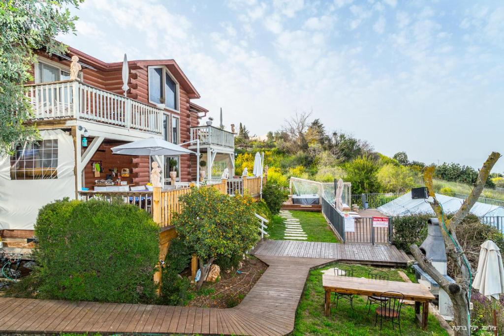 a log house with a deck and a patio at Vibe Naftali Estate in Ramot Naftali