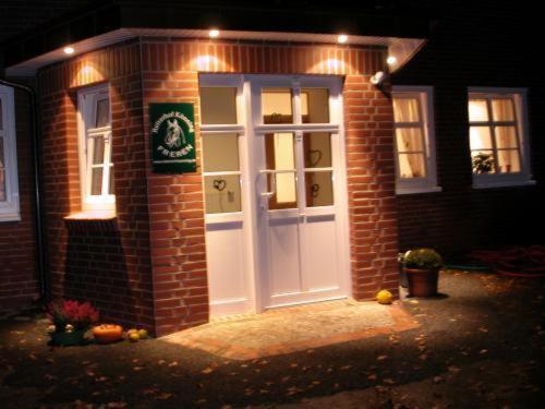 une maison en briques avec une porte et des lumières blanches dans l'établissement Reiterhof Könning, à Freren