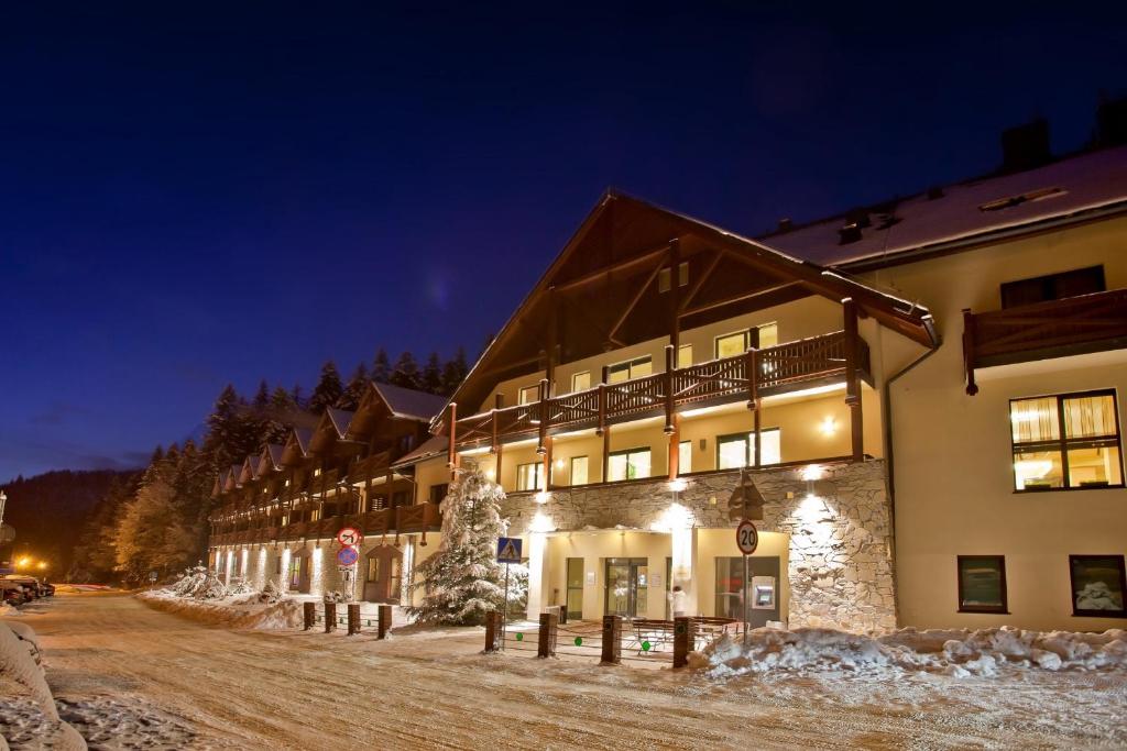un edificio nella neve di notte di Wierchomla Ski & Spa Resort a Piwniczna