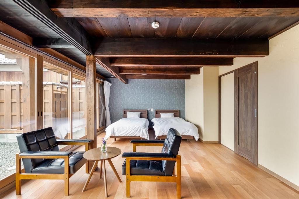 a bedroom with a bed and two chairs and a table at Satsuki  in Gojō