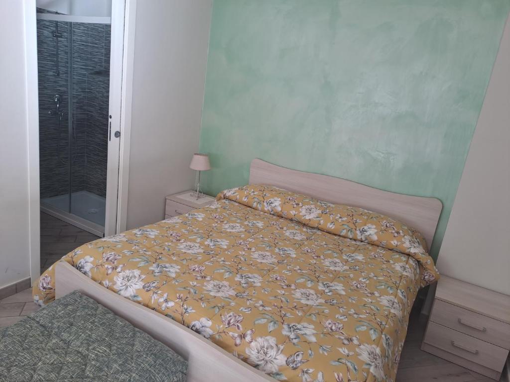 - une chambre dotée d'un lit avec un couvre-lit floral dans l'établissement La Rosa Verde, à Castrovillari