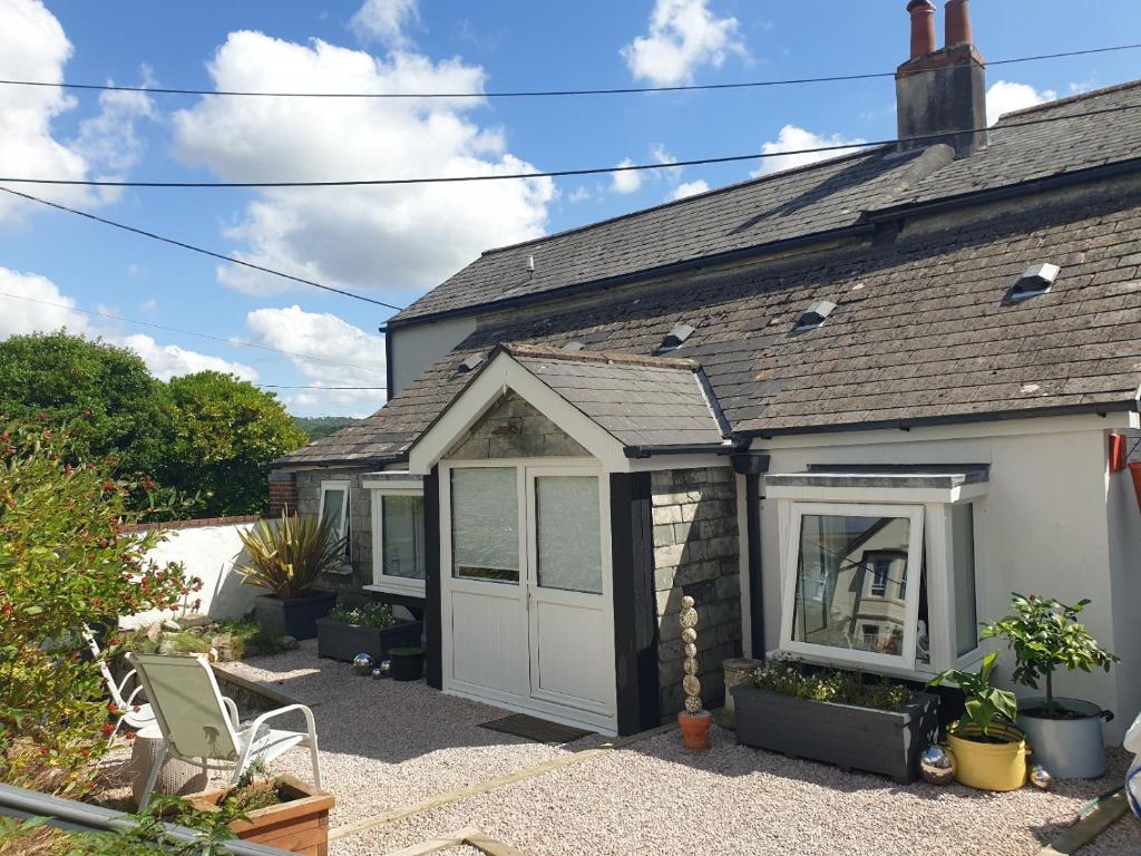 a house with a white door and a patio at Bracken's Retreat in Lostwithiel