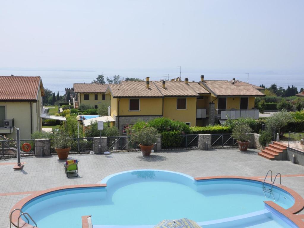 a large swimming pool in a yard with houses at Apartment in Lazise with Lake View Balcony in Lazise