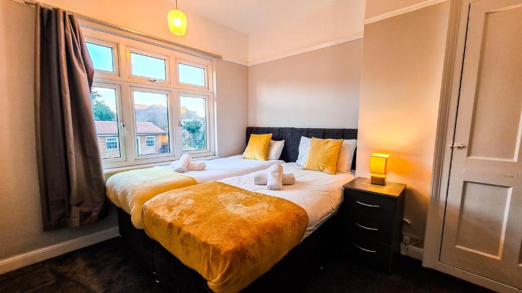 2 camas en una habitación con ventana en Modern Contractor Housing - FREE WiFi and parking!, en Luton