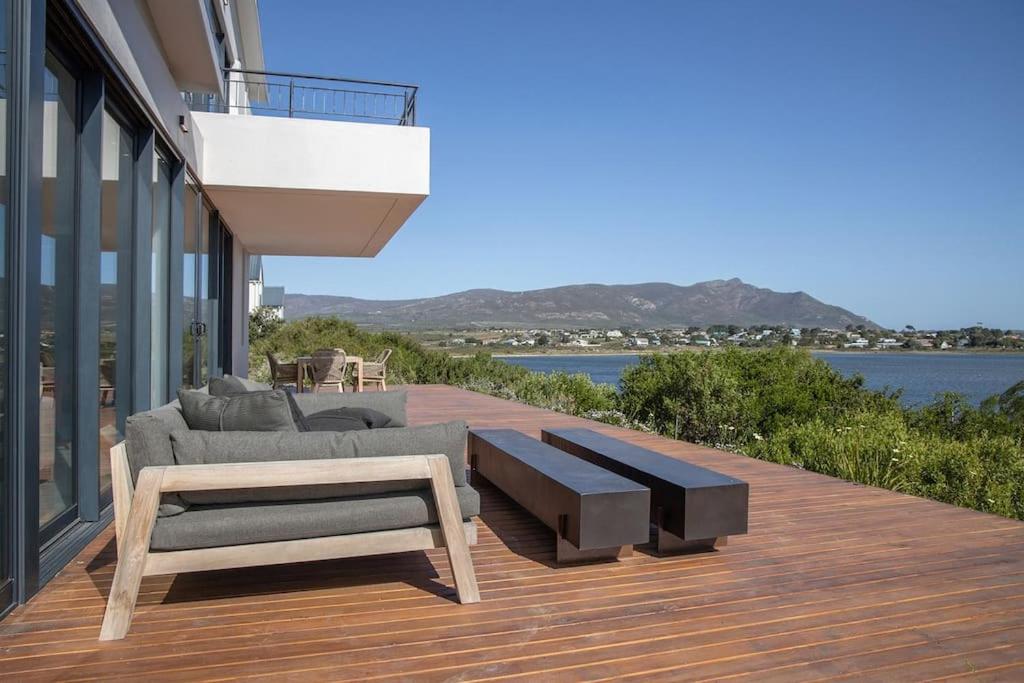 a wooden deck with a couch and a coffee table at Coastal Retreat, wine and relax in Hermanus