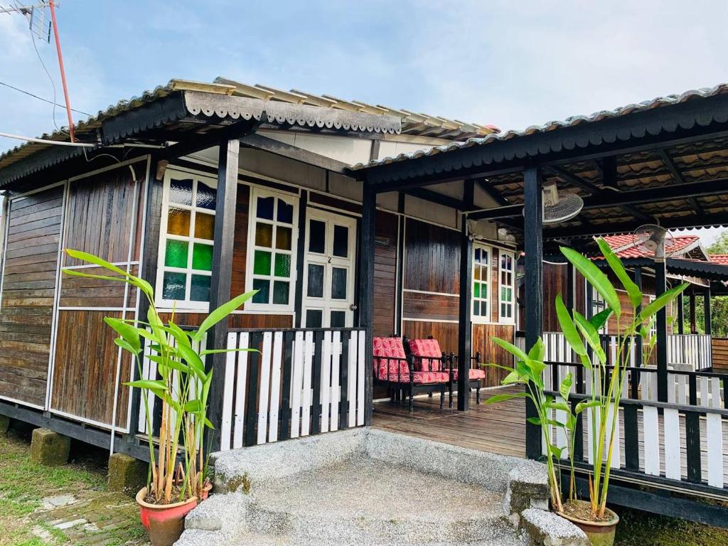 una casa con una terraza de madera y algunas plantas en MOSS HEDERA HIDE CHALET, en Melaka