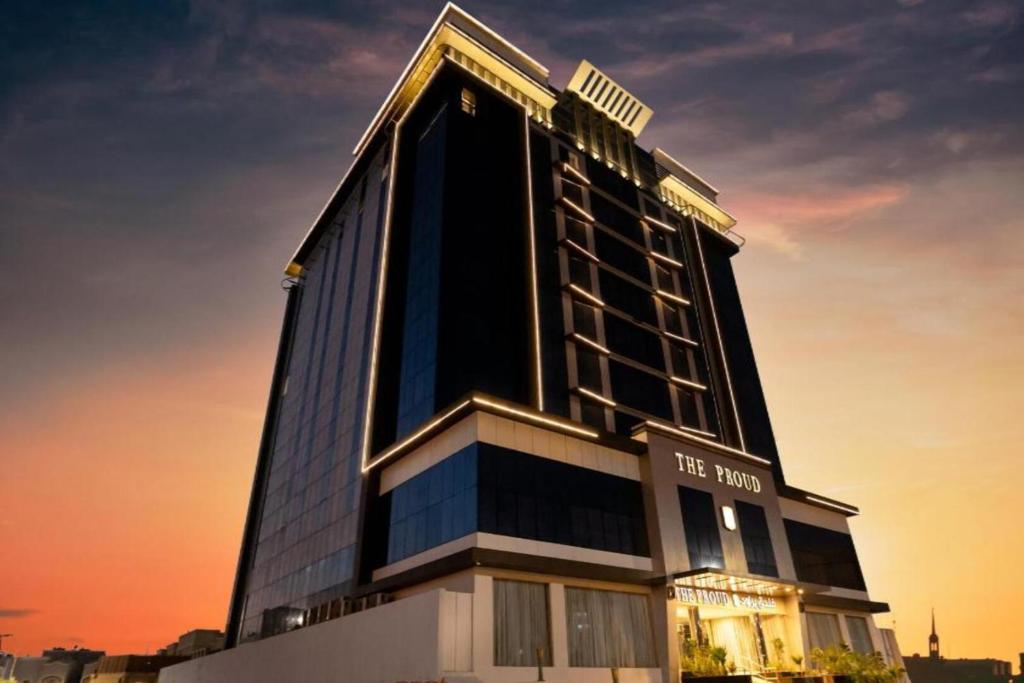 a tall black building with a sign on it at The Proud Hotel Al Khobar in Al Khobar