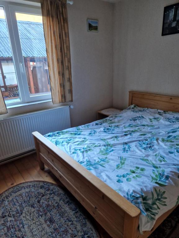 a bedroom with a large bed with a blue blanket at Casa Jan Bonca in Lorău