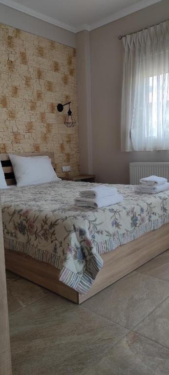 duże łóżko w sypialni z ceglaną ścianą w obiekcie House Kallisti 2 w mieście Sykia