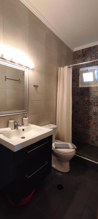 łazienka z umywalką, toaletą i lustrem w obiekcie House Kallisti 2 w mieście Sykia