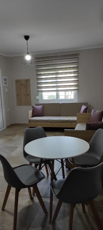 salon ze stołem, krzesłami i kanapą w obiekcie House Kallisti 2 w mieście Sykia