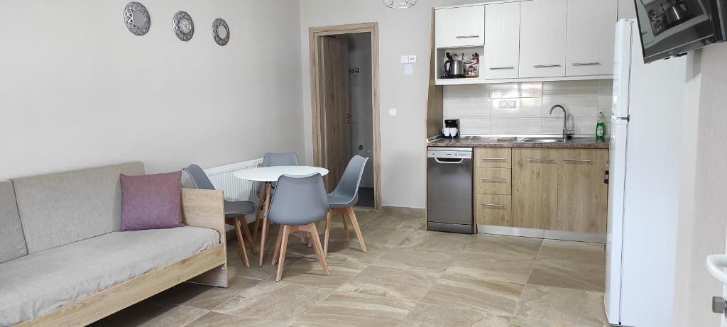salon z kanapą i stołem oraz kuchnia w obiekcie House Kallisti 2 w mieście Sykia