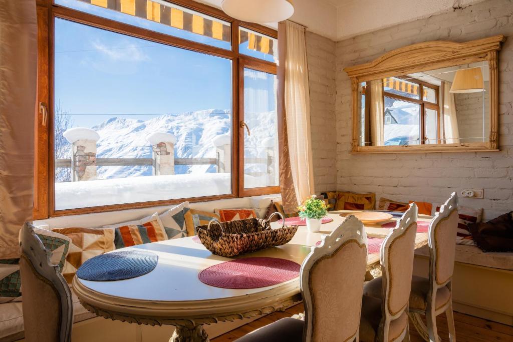 a dining room with a table and chairs and a window at Snow Time Cottage in Gudauri