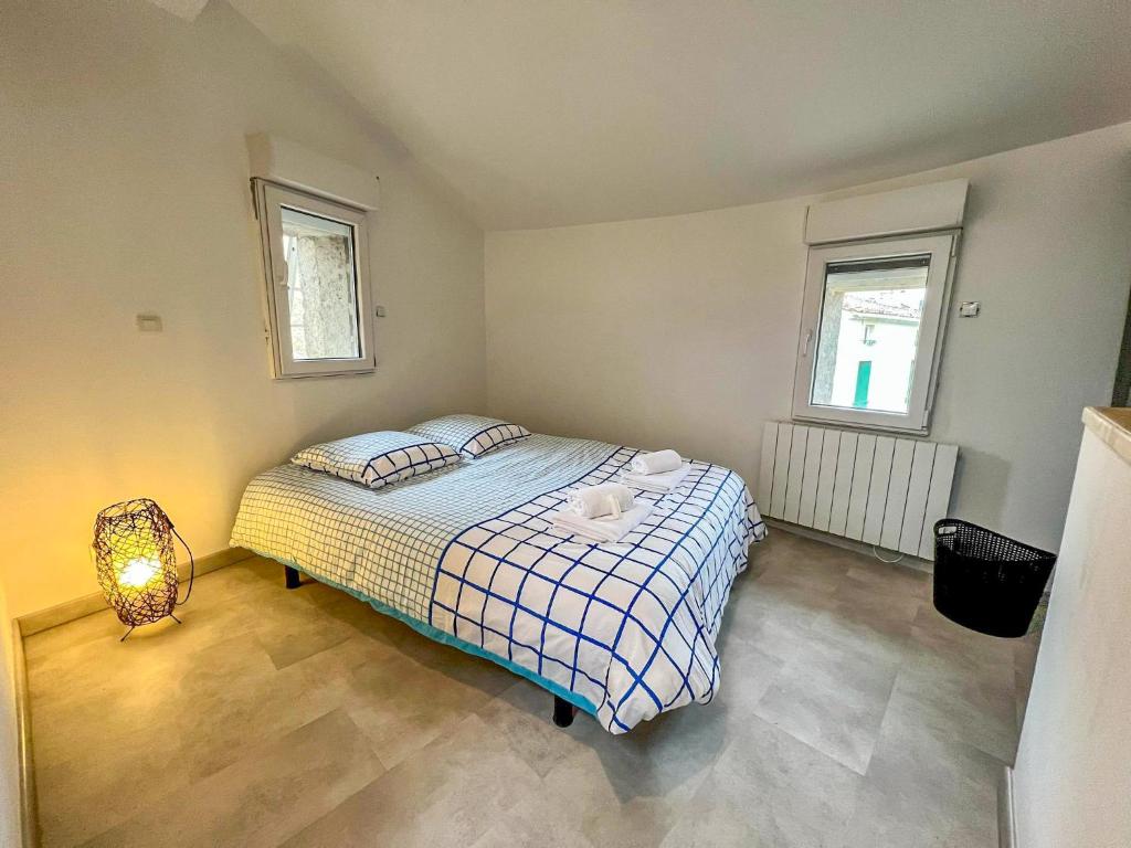 niewielka sypialnia z łóżkiem i 2 oknami w obiekcie Maison de Caractère rénovée avec gout pour 2 personnes w mieście Saint-Geniès-de-Fontedit