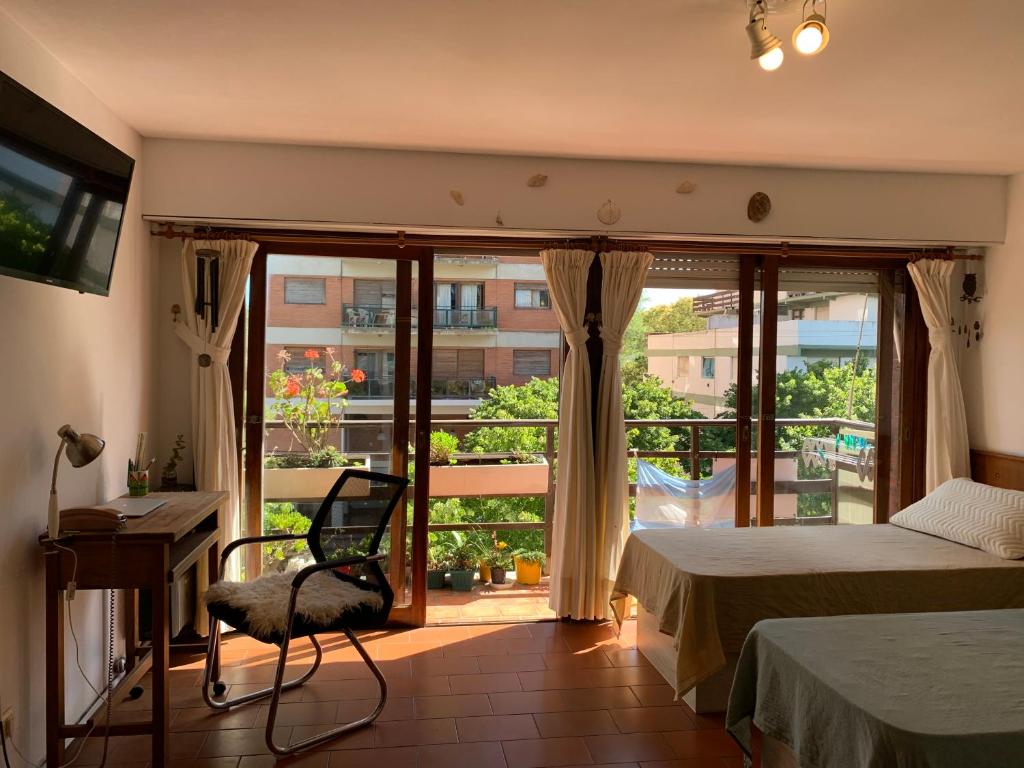 1 dormitorio con 1 cama y balcón con vistas. en Lindo y cómodo departamento en Pinamar - Otilia Residencias en Pinamar