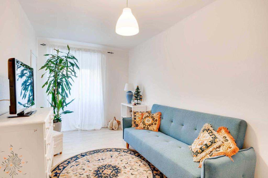 a living room with a blue couch and a tv at Casa da Avó Maria in Arraiolos