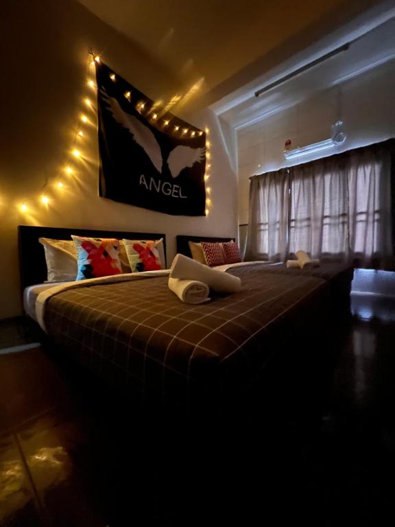 a bedroom with a large bed with aania sign on the wall at Room2#IG theme Bargainous#Shared Bathroom#4pax#2min Kek Lok Si in Ayer Itam
