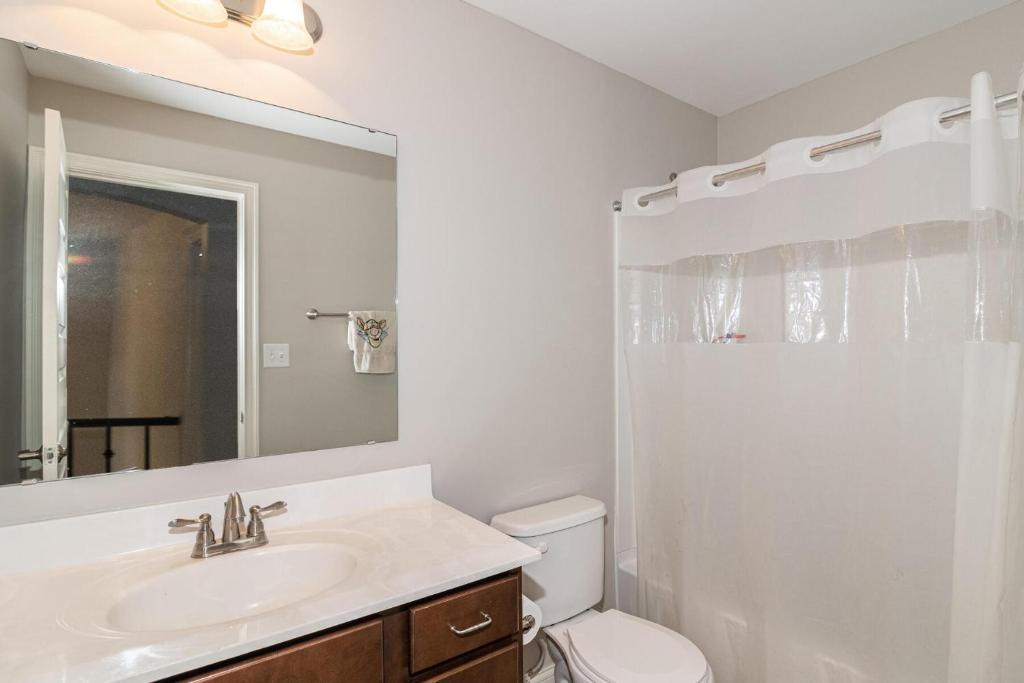 uma casa de banho com um lavatório, um WC e um espelho. em Lakefront view private bedroom and bathroom with kitchen em McCordsville