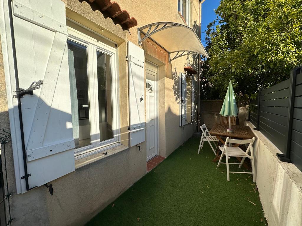 d'une terrasse avec une table et des chaises sur le côté de la maison. dans l'établissement Studio avec terrasse-Orange Vélodrome, à Marseille