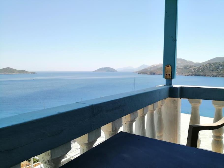 a bench on a balcony with a view of the water at RODON PIGANOUSA STUDIO in Spilia Leros in Panteli