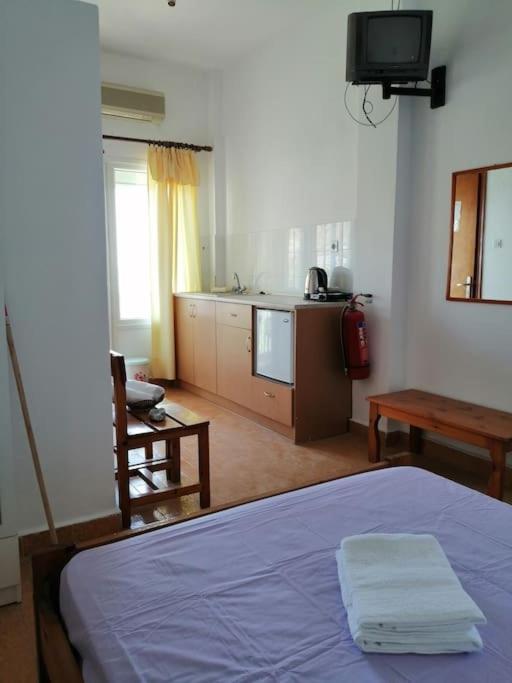 sypialnia z niebieskim łóżkiem i kuchnią w obiekcie RODON PIGANOUSA STUDIO in Spilia Leros w mieście Panteli