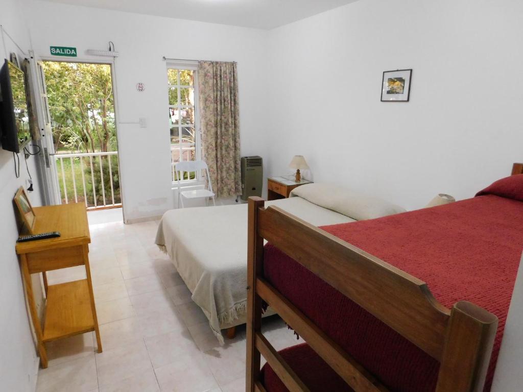 una camera con letto e finestra con balcone di Hostería Teuly a Puerto Madryn