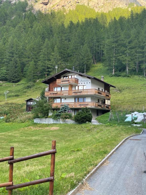 a house on a hill next to a road at Haus Antares in Saas-Almagell