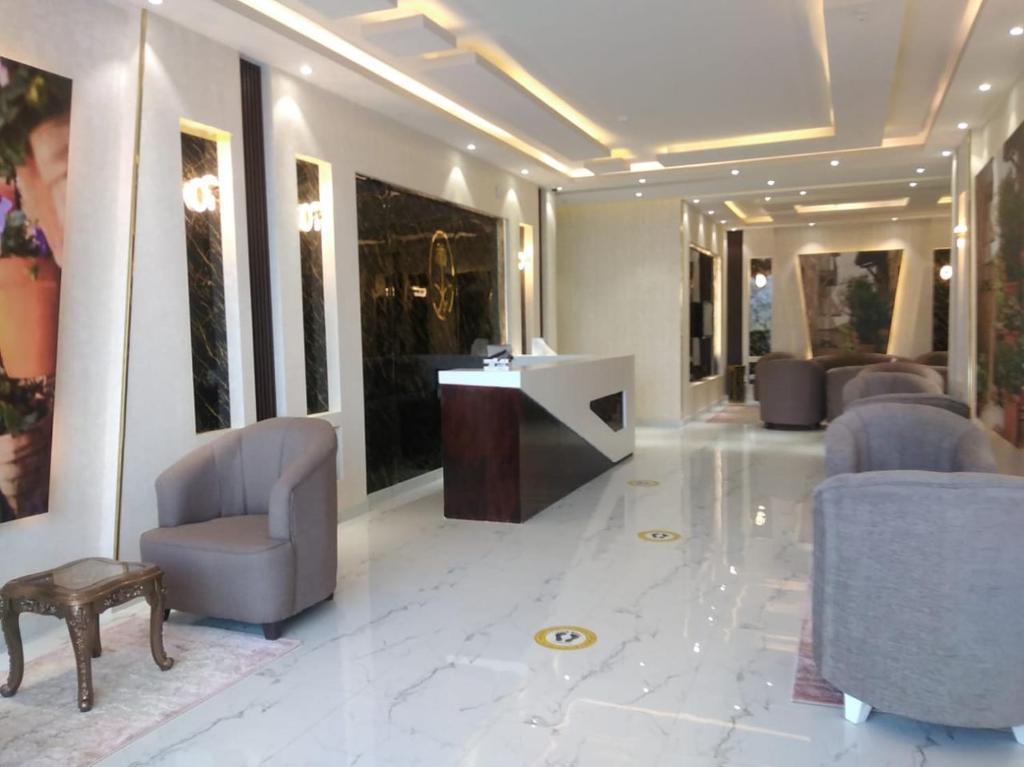 vestíbulo con sillas y escritorio en un edificio en Admire Apart Hotel - 2, en Aḩad al Masāriḩah