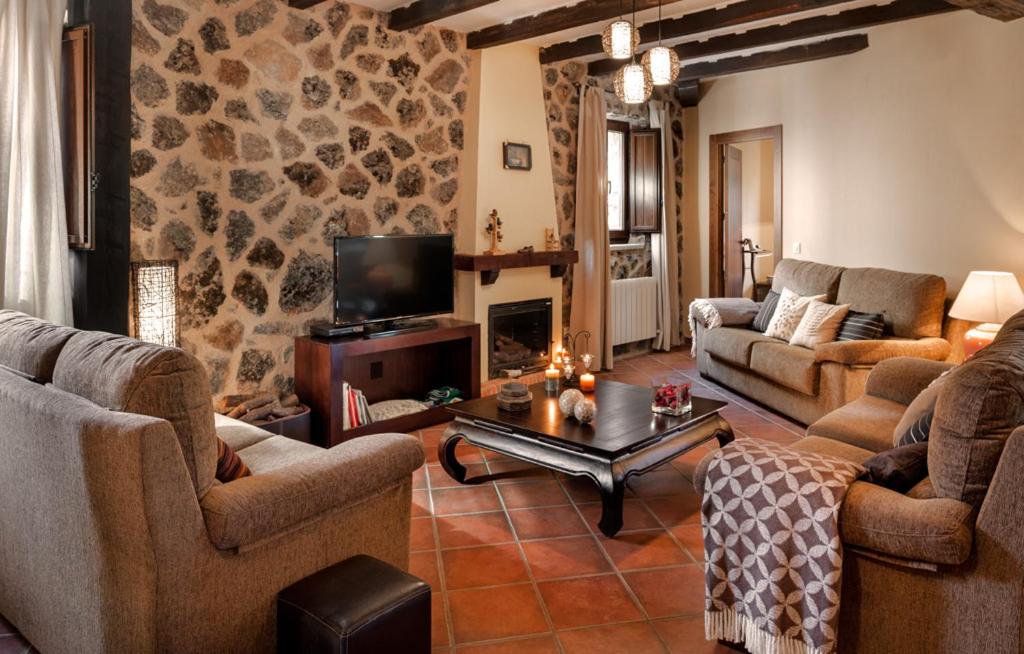 sala de estar con 2 sofás y chimenea en Casa Rural El Caldero, en Sorihuela